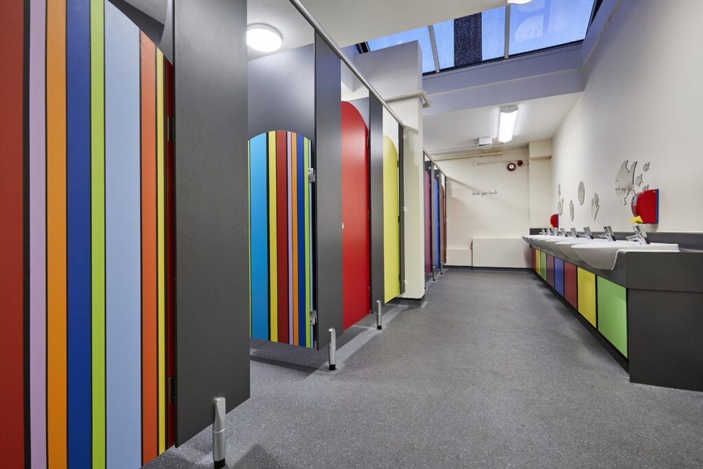 Colorful office toilet facility with vibrant cubicles and sinks